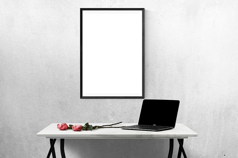 black laptop computer turned-off on white wooden table near black wooden photo frame HD wallpaper