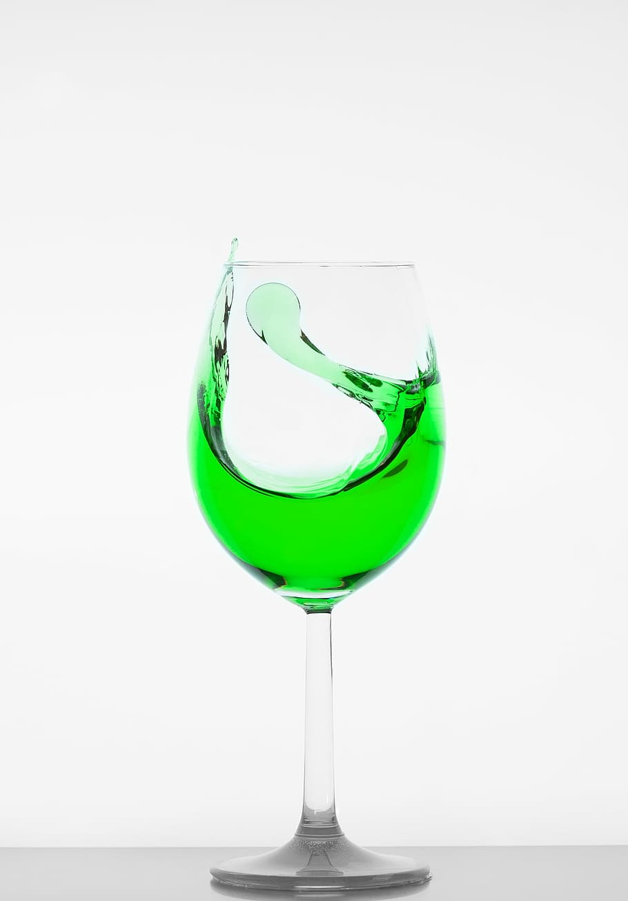 clear wine glass filled with green liquid, crystal glass, drinking cup