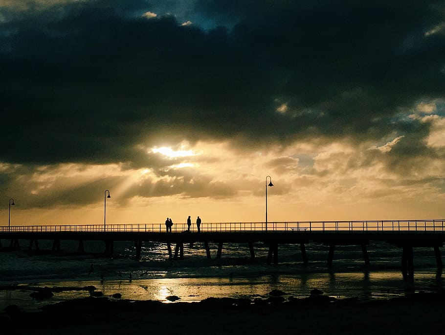 silhouette of four people standing on sea dock, silhouette photography of people on bridge during golden hours HD wallpaper