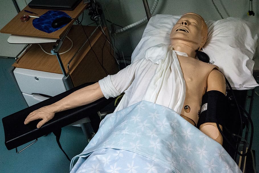 medical training dummy on hospital bed in room, paramedics doll