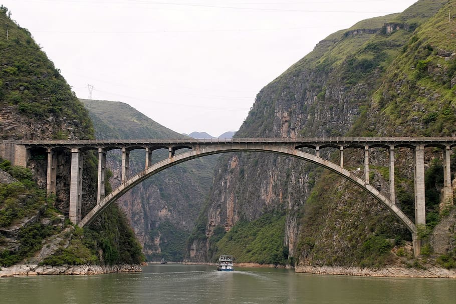 gray concrete bridge near over river near mountains, blue sky HD wallpaper