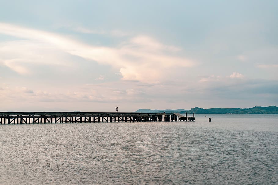 brown wooden sea dock, brown wooden dock near mountain at daytime HD wallpaper