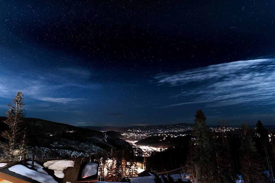 scenery of city building and forest, aerial photo of city beside mountains during nighttime HD wallpaper