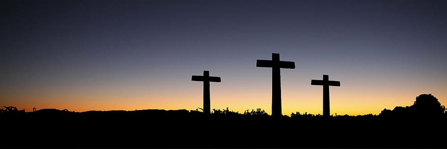 low light photo of three cross stands, banner, header, easter
