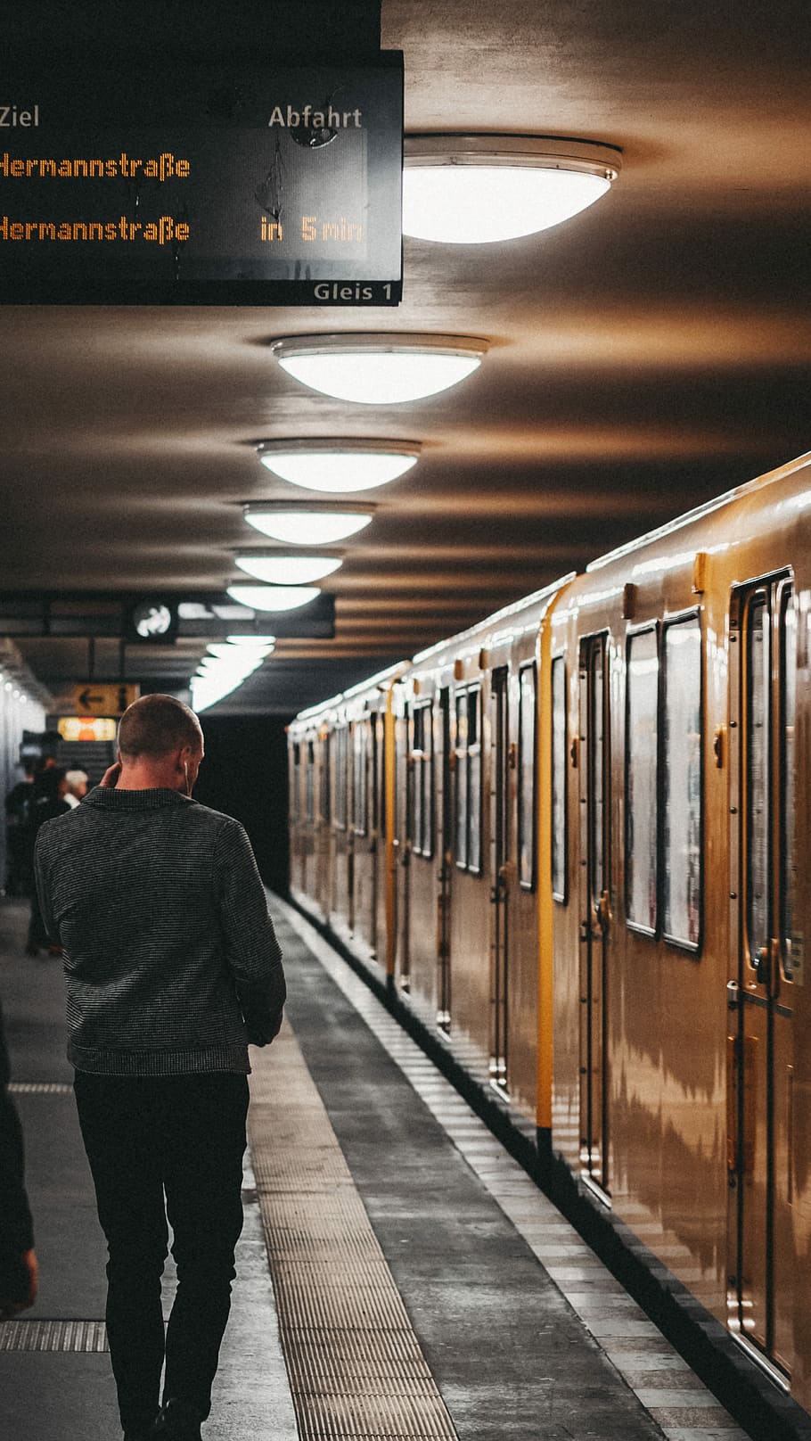 man walking near subway train, man walking beside train, citylife