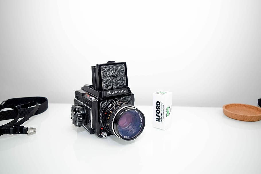 black Mamiya point-and-shoot camera in white table, black Mamiya land camera beside black strap, HD wallpaper