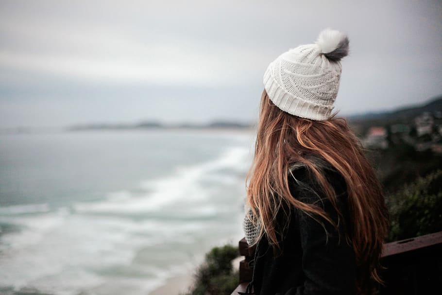 woman facing body of water, woman looking on open sea wearing white knit bobble cap, HD wallpaper