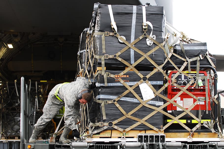 man tying luggage, loading, cargo, pallet, transport, industrial HD wallpaper