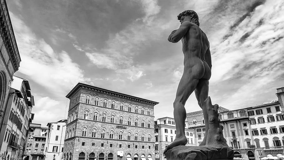 grayscale photo of Statue of David near buildings, michelangelo