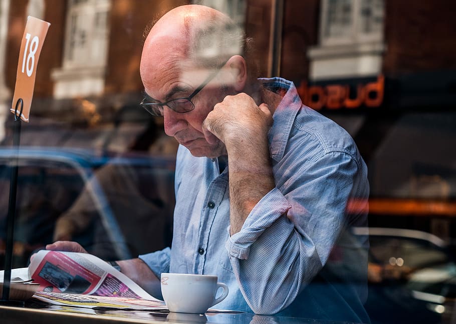 man reading book, man reading magazine near glass windowpane HD wallpaper