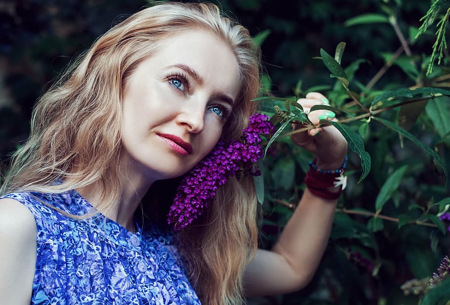 woman wearing blue and white floral sleeveless tops holding purple cluster flower HD wallpaper