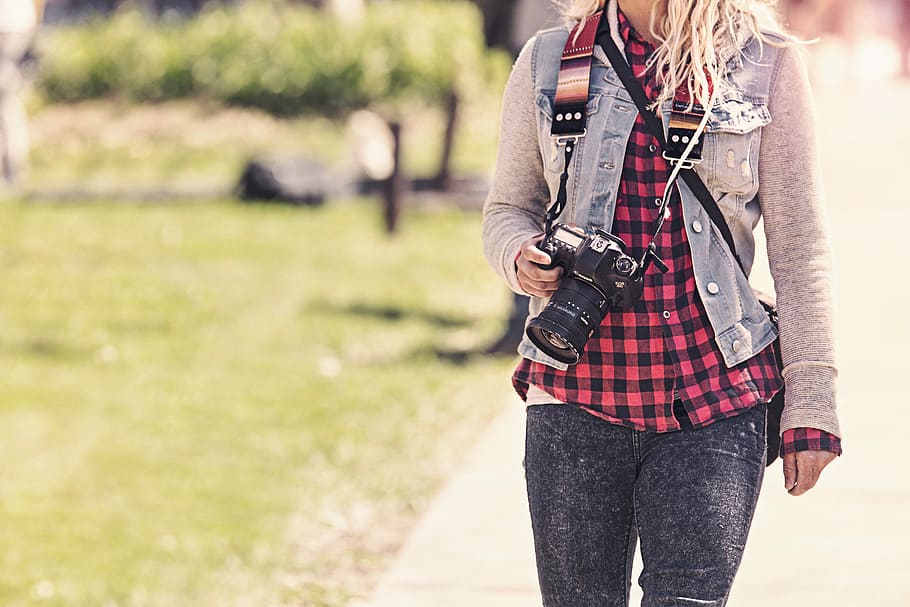 selective focus photo of woman holding DSLR camera, people, object
