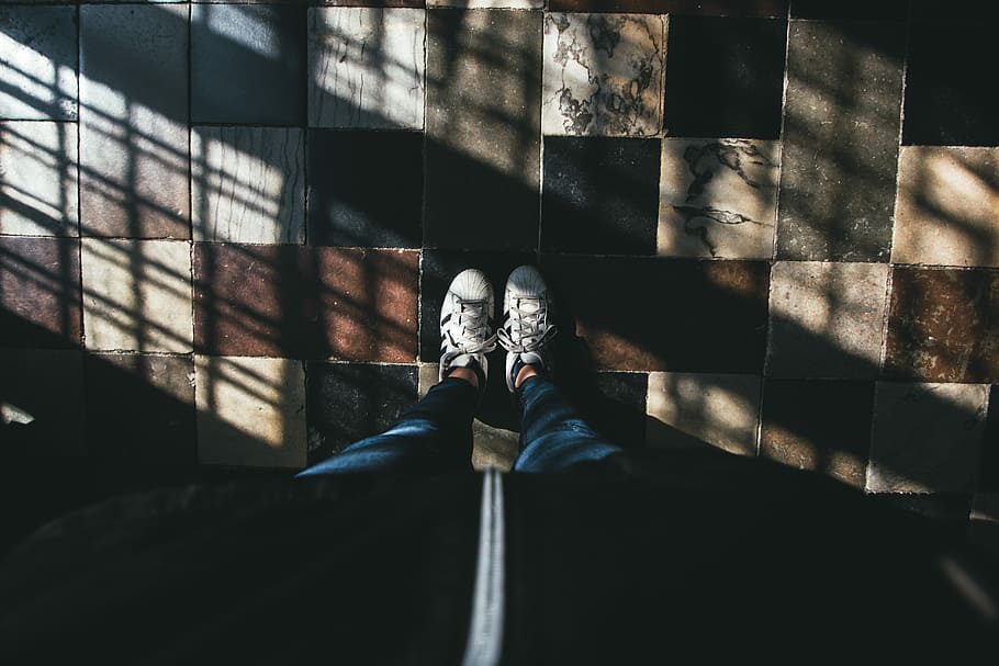high-angle of person in blue pants and white sneakers standing on floor tiles, person in blue jeans wearing white sneakers inside lighted room HD wallpaper
