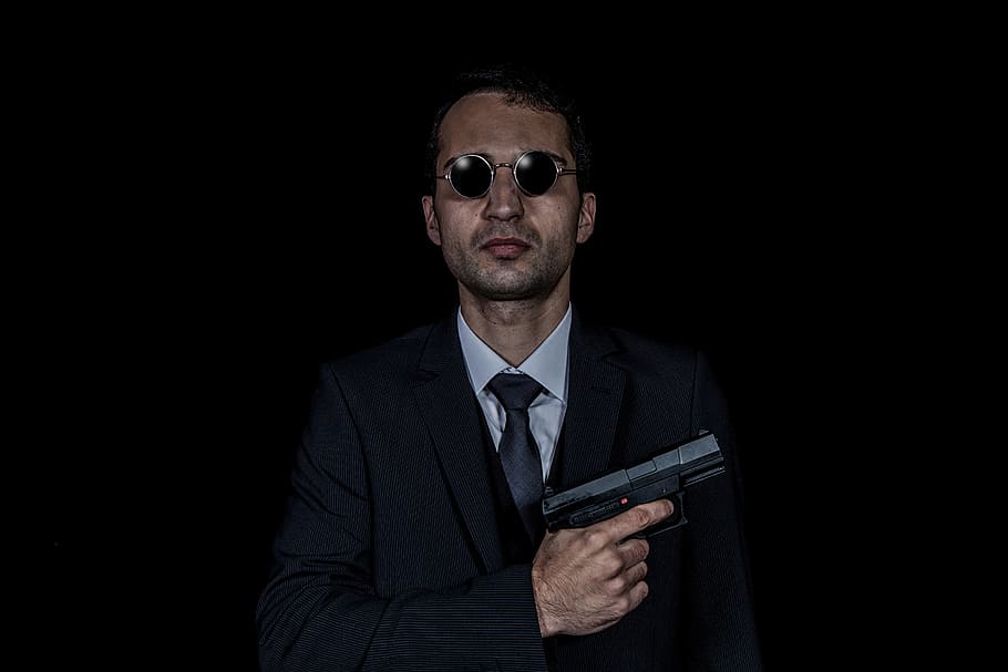man in black suit jacket and black necktie holding black semi-automatic pistol with black hippie sunglasses, HD wallpaper