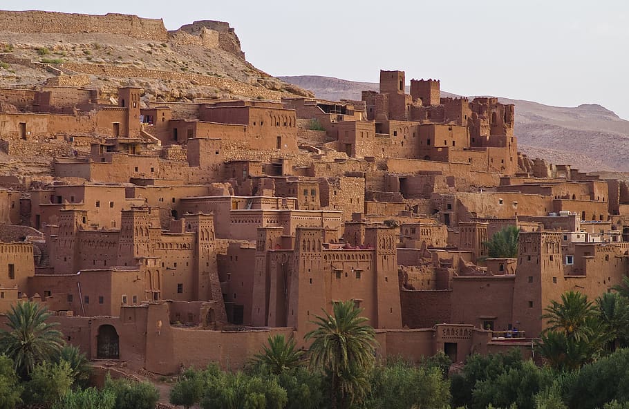 city by mountain slope under grey skies, ait ben haddou, world heritage