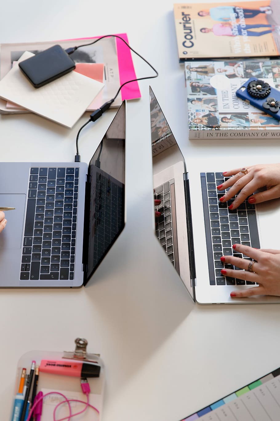 person typing on silver laptop computer, flat lay photography of person holding MacBook beside book and smartphone