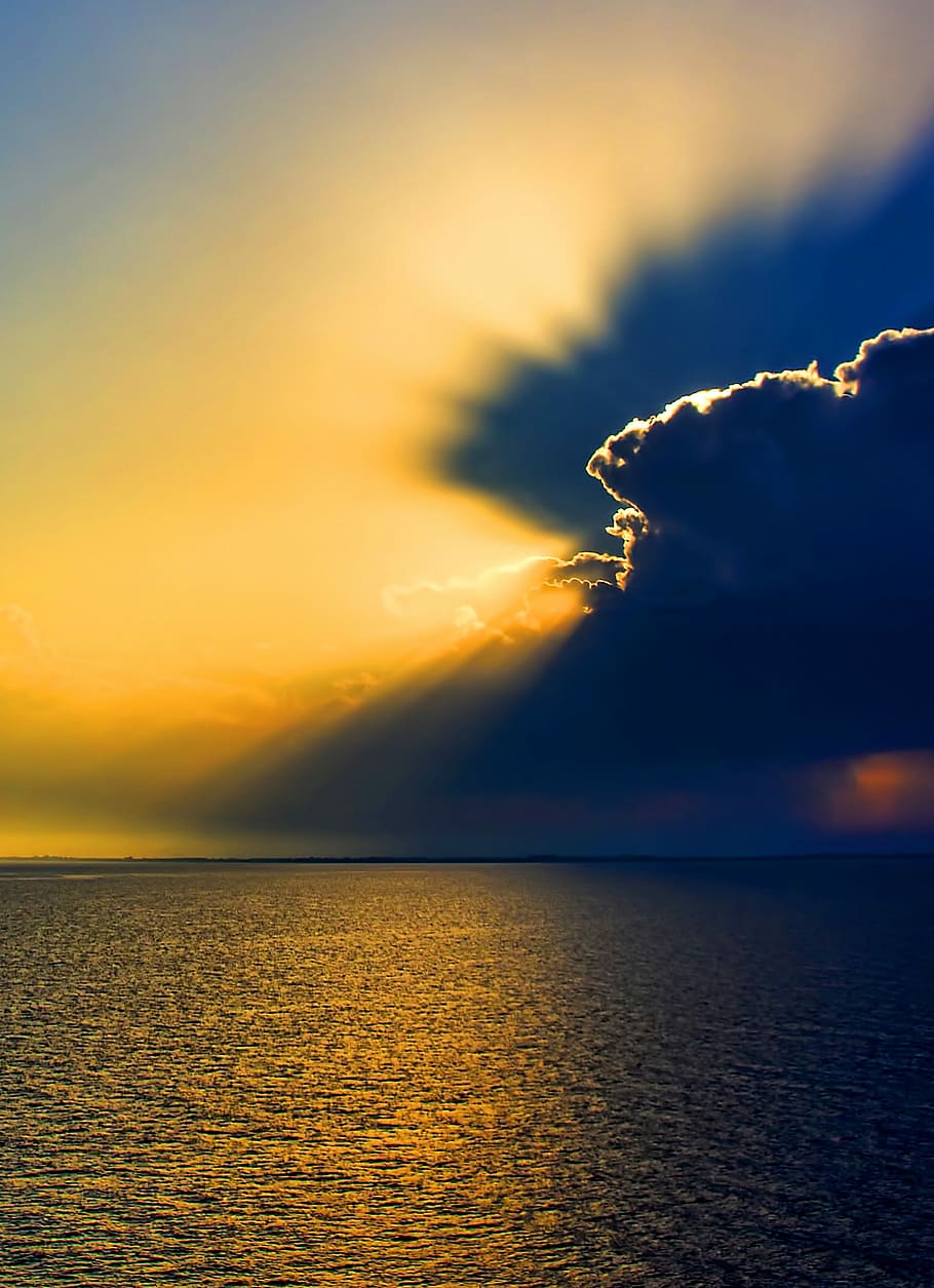 landscape photography of ocean, body of water under yellow cloudy sky HD wallpaper