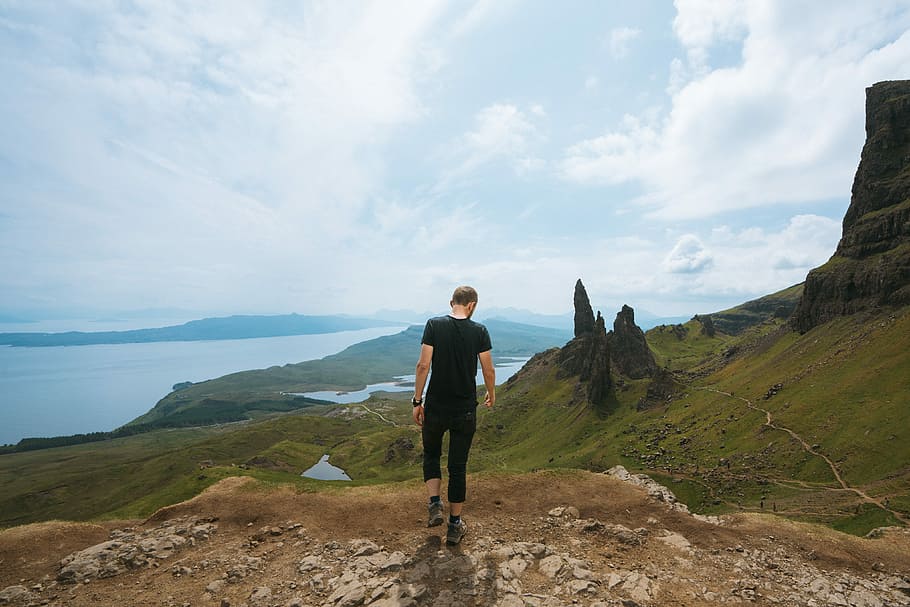 man standing on mountain peak, man wearing black shirt walking HD wallpaper