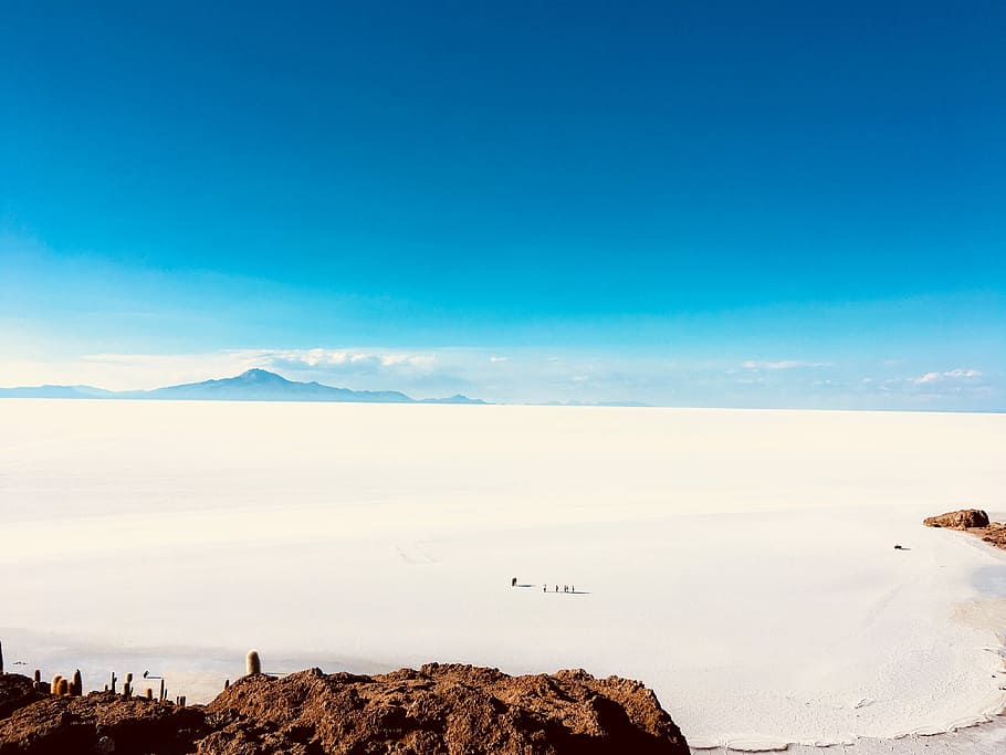 people walking on vast snow-covered plain, mountain, rock, sky HD wallpaper