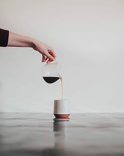 person pouring coffee in white mug, person pouring black liquid on white ceramic cup HD wallpaper