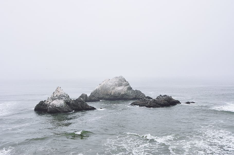 gray and black rock formation in between of body water photo, rocks in sea waves HD wallpaper