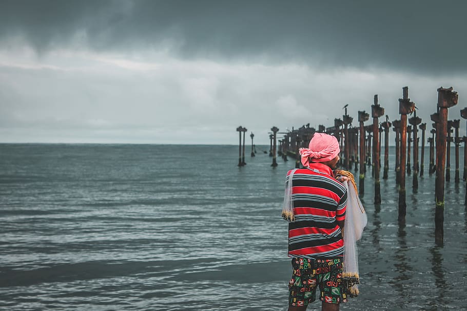person standing beside body of water, man standing near seashore HD wallpaper