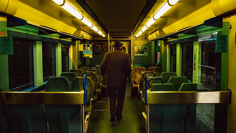 man walking inside train, person walking on train seats, transport