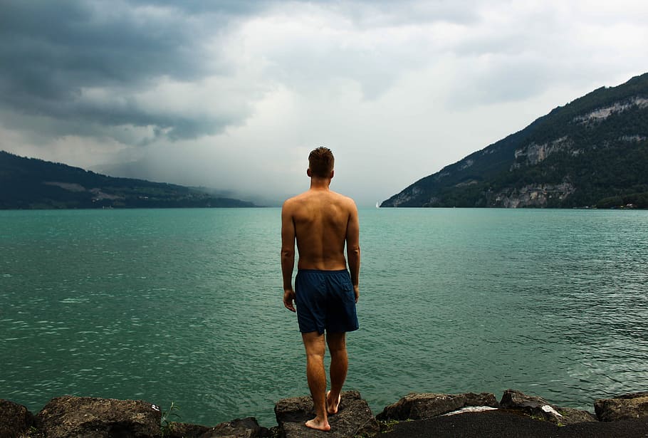 man in black short standing on rock beside lake, men, one Person, HD wallpaper