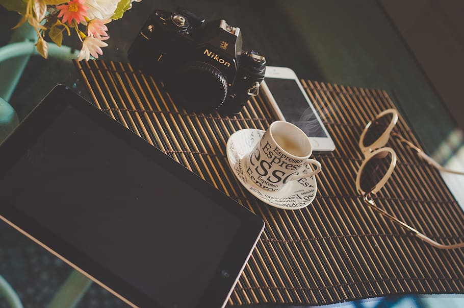 black iPad on table near Nikon DSLR, coffee, boot, startup HD wallpaper