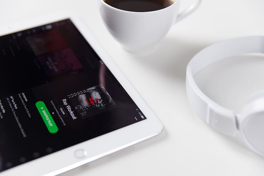 White iPad tablet computer alongside music headphones and coffee HD wallpaper