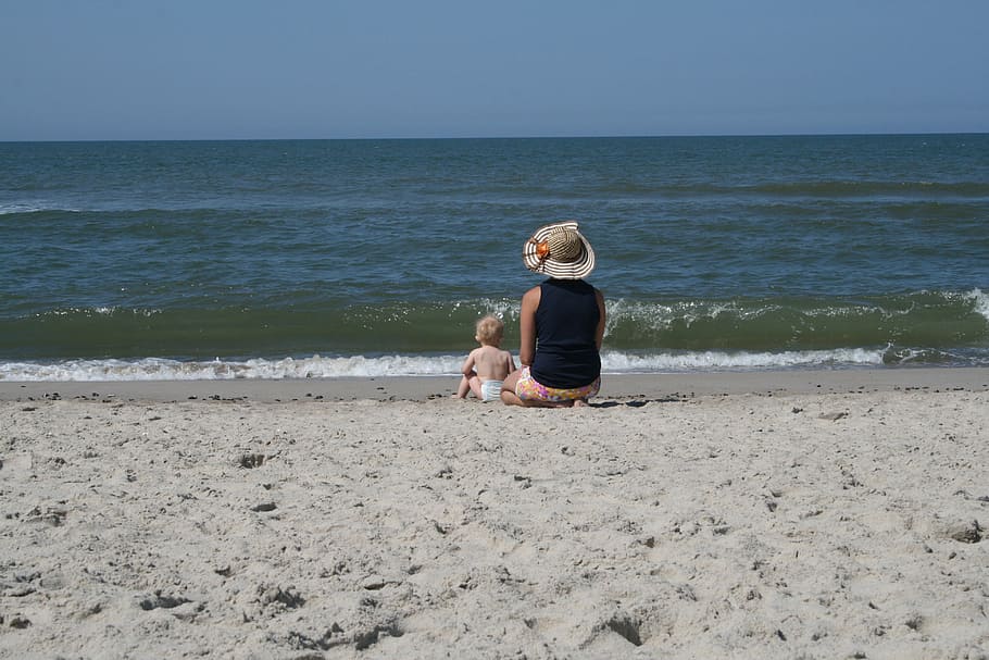 woman and baby sitting on shore, beach, sand, sea, wave, north sea HD wallpaper