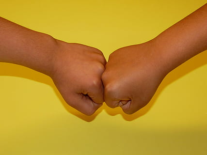 close-up photo of two human fists on yellow surface, faust HD wallpaper