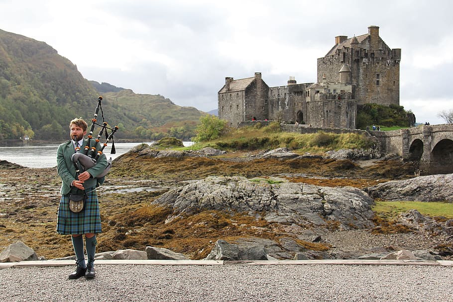 man holding bagpipe near castle, bagpipes, highlander, scottish
