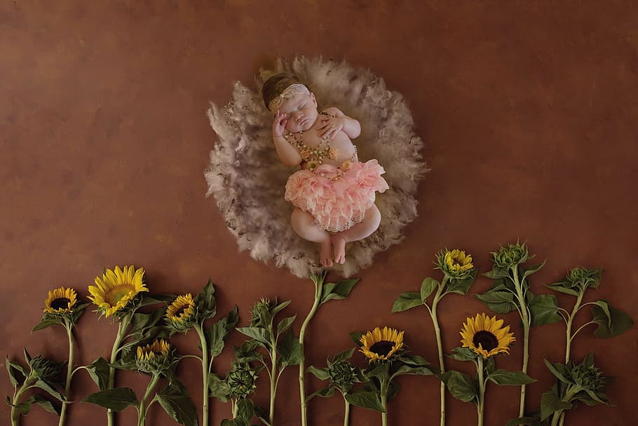 baby in pink skirt near yellow sunflowers, newborn, prop, photography