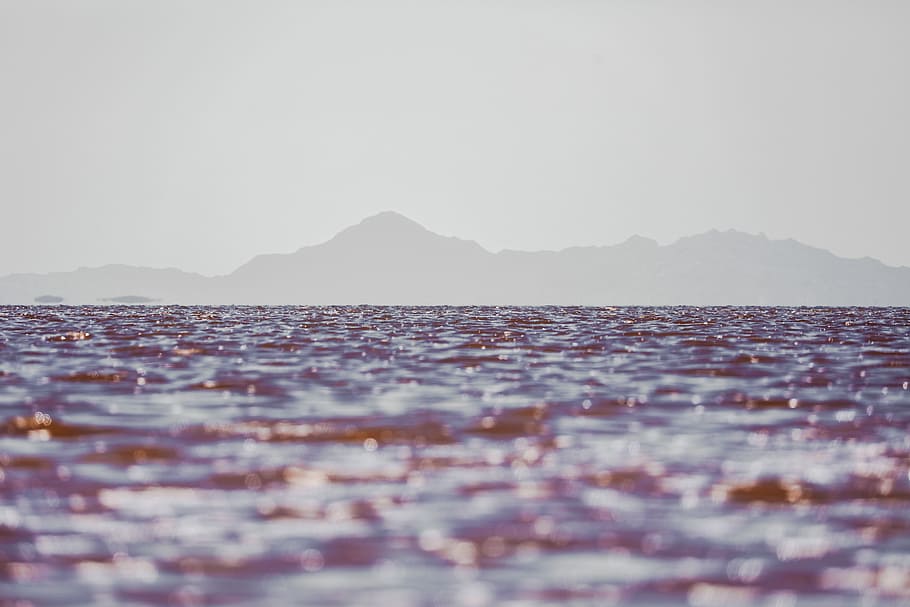 ocean waters with mountain at the distance, close up photo of body of water with mountain silhouette background HD wallpaper