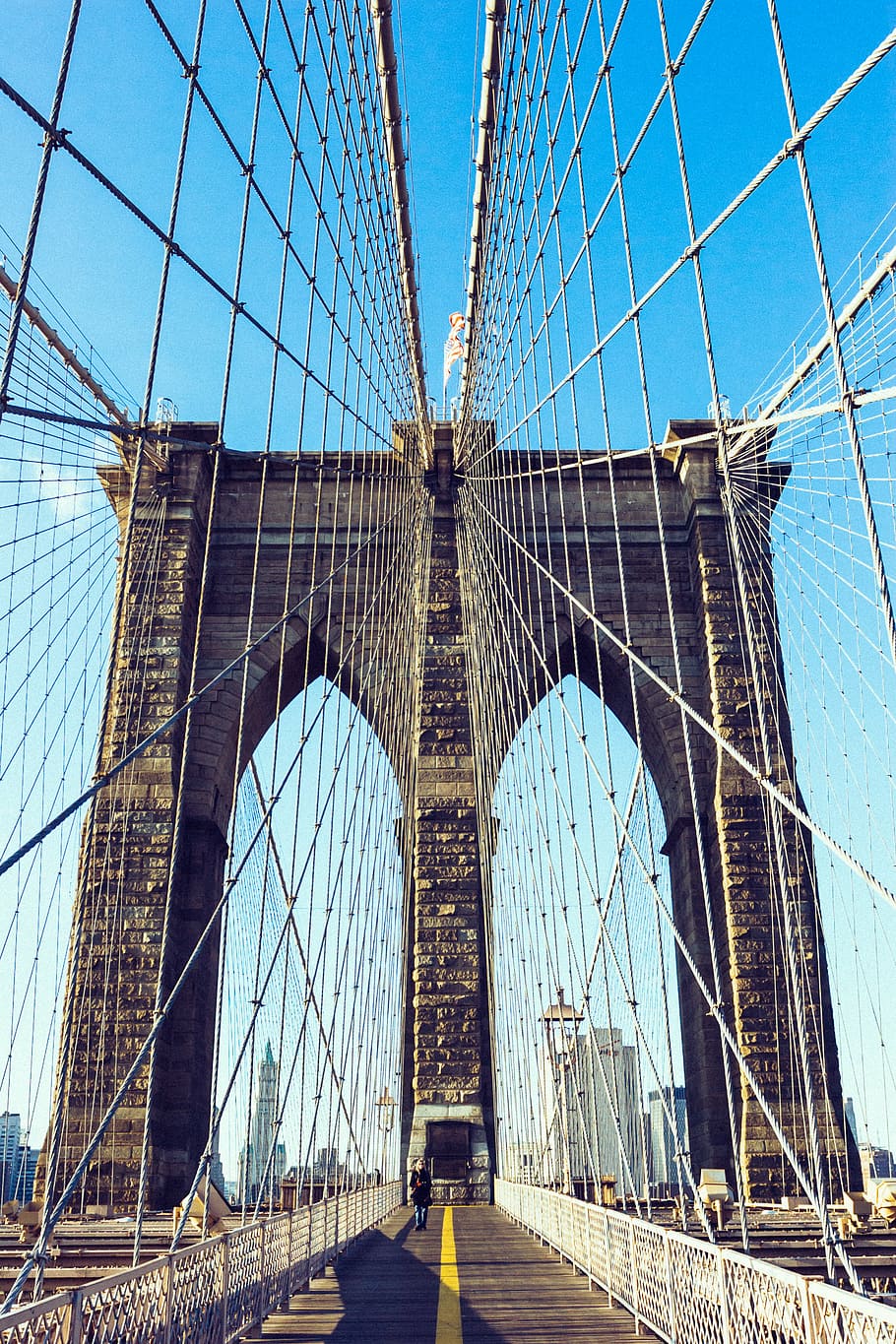 person walking on brown concrete suspension bridge at daytime HD wallpaper