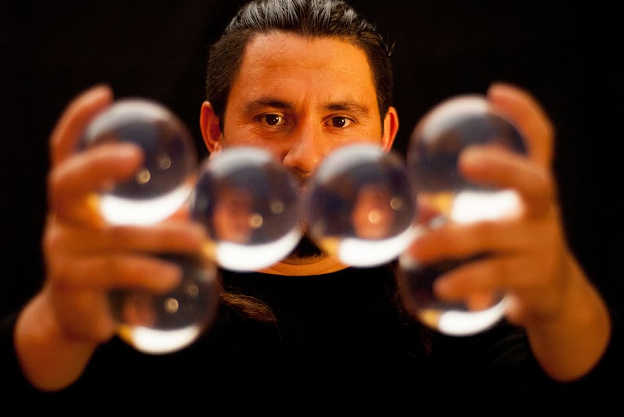 selective focus photography of man holding clear glass balls HD wallpaper