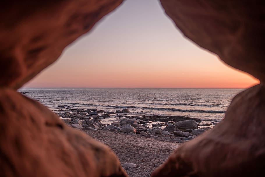 shallow focus photography of stones beside water, rock formation near sea during golden hour HD wallpaper