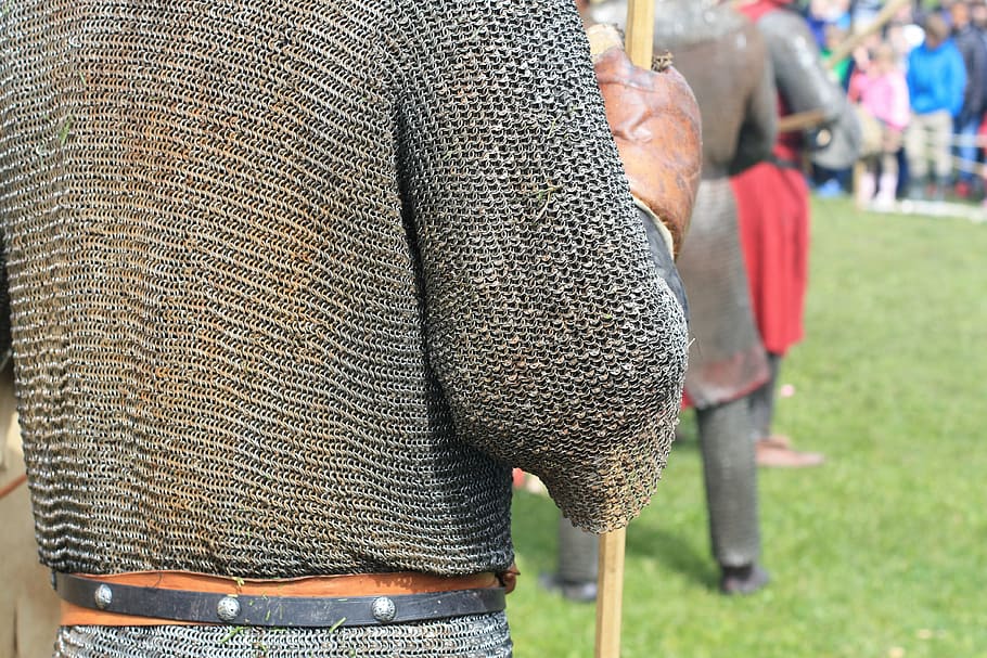 person in warrior suit standing on grass field, chain armor, chainmail