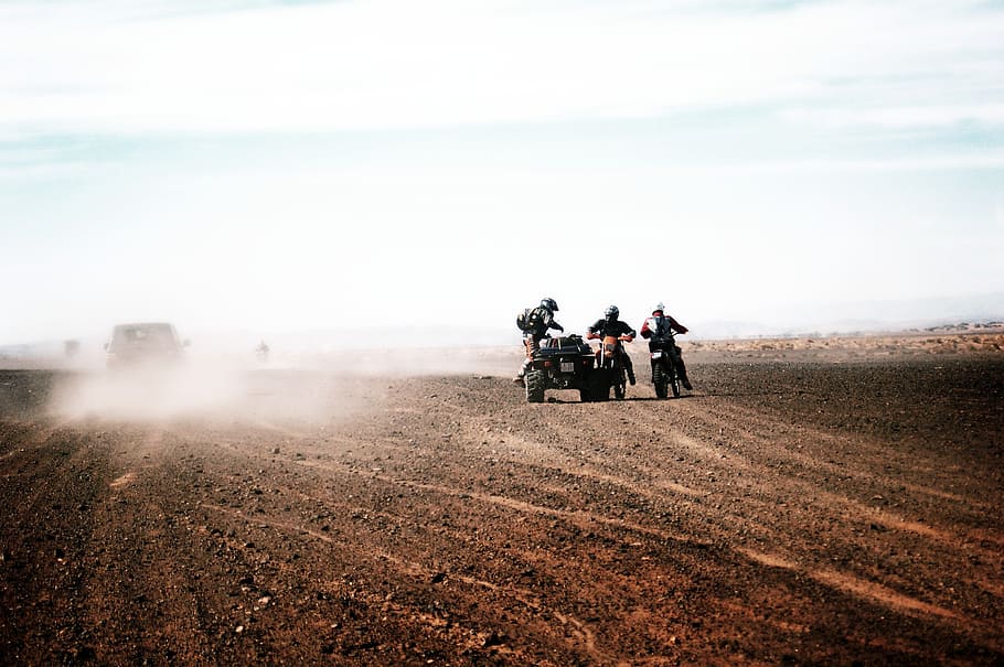 three men rides motorcycle and ATV on desert, motocross, speed