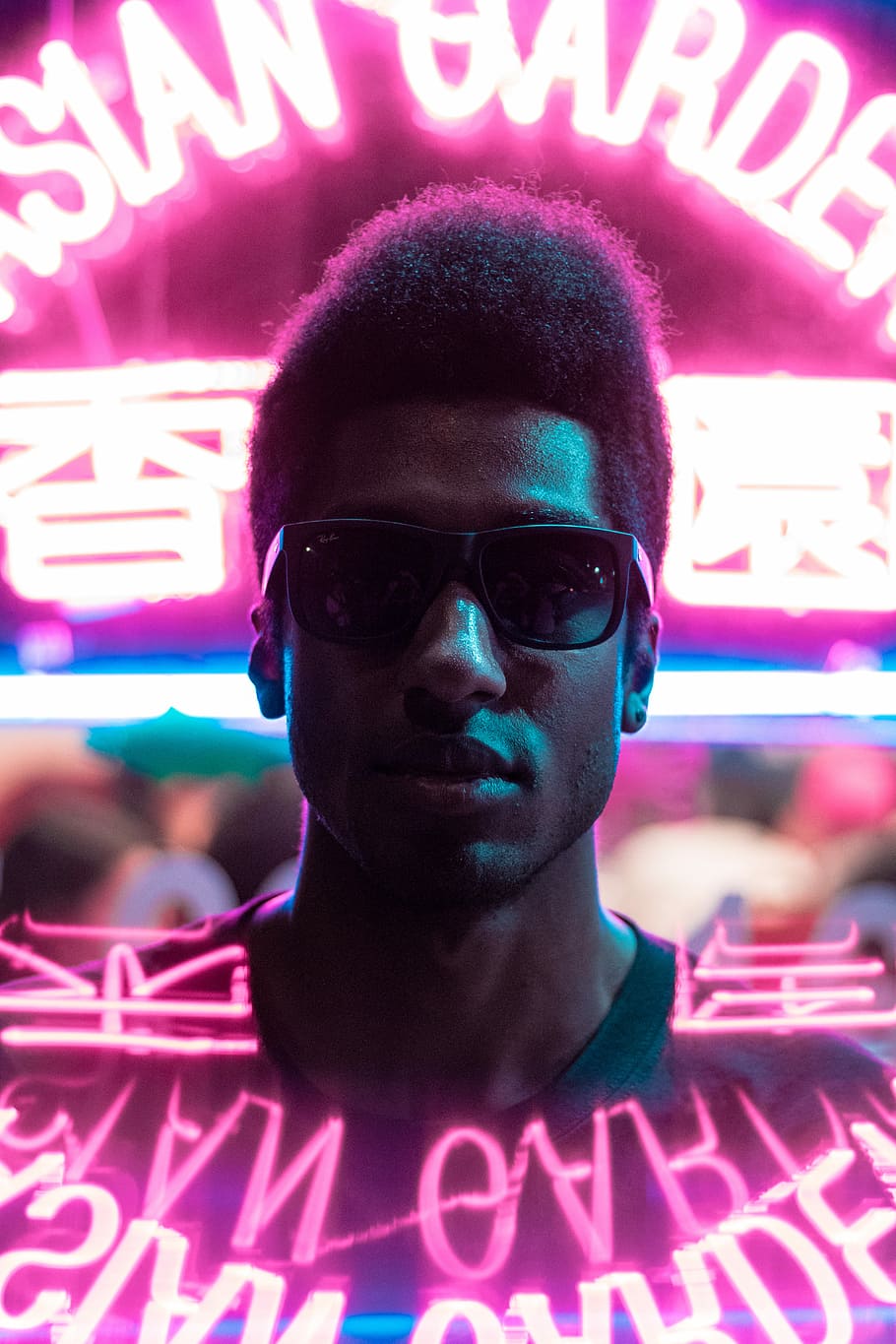 man standing in front of neon signage, man wearing green crew-neck top and black sunglasses, HD wallpaper