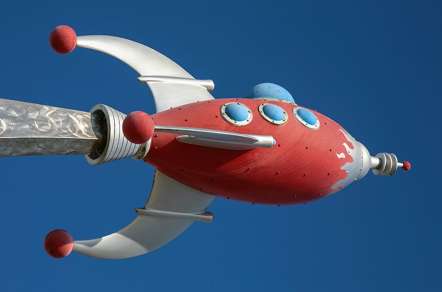 photo of gray and red spaceship building, red and white space ship figurine at daytime HD wallpaper