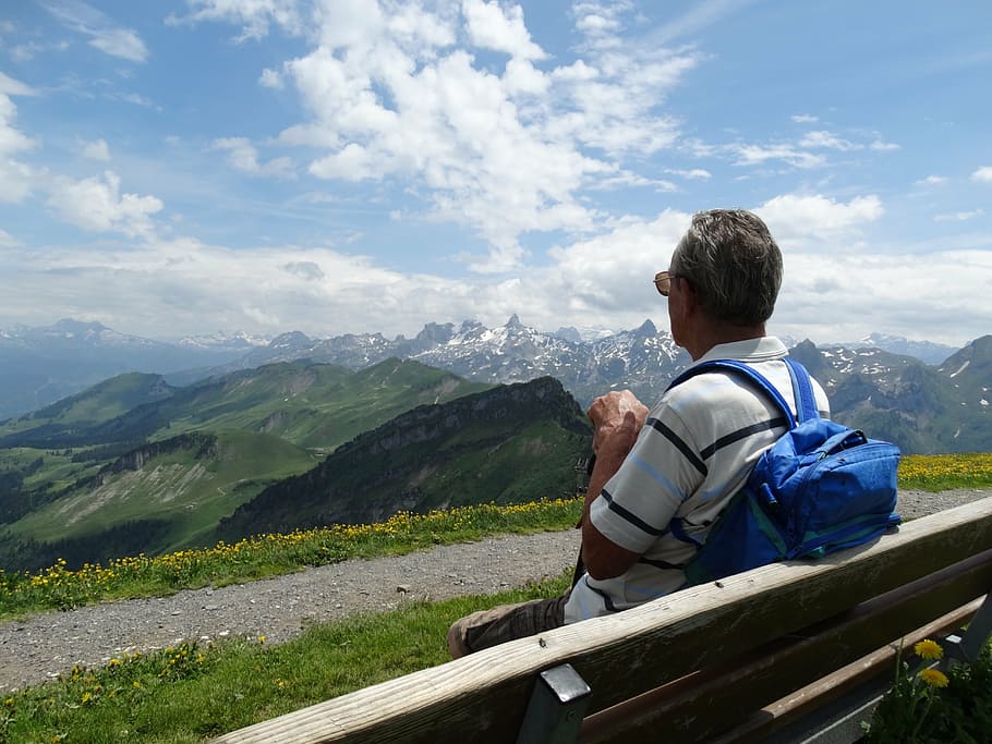 man leaning on gray fence under cloudy sky, bench, foresight HD wallpaper