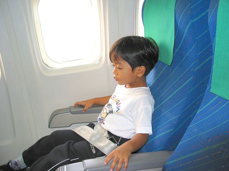 boy sitting on plane seat with belt on, child, airplane, seat belt