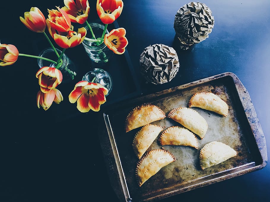 red-and-yellow tulip flowers beside pan of empanada, seven HD wallpaper