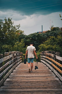 man walking on brown wooden bridge, man holding DSLR camera while walking on bridge HD wallpaper