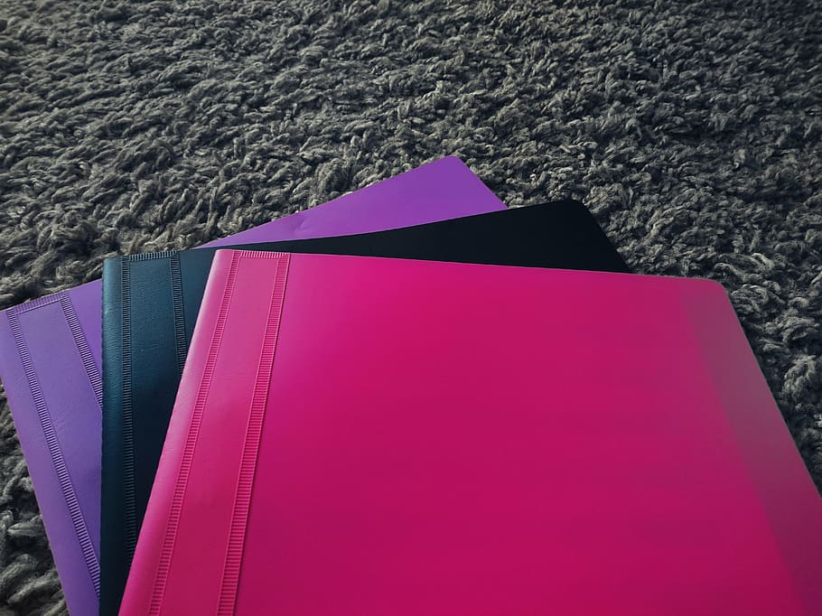 three assorted-color plastic folders on gray fleece textile HD wallpaper