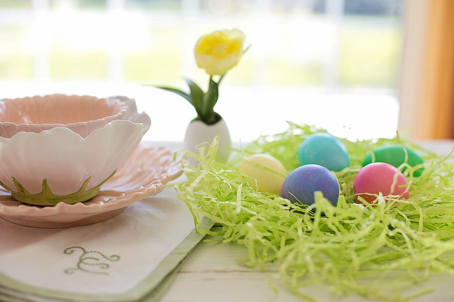 five assorted-color eggs on table beside a teacup on coaster HD wallpaper