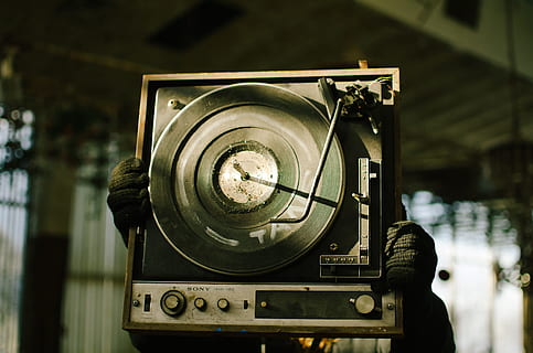 black and brown vinyl turntable, person holding black and gray Sony vinyl player HD wallpaper