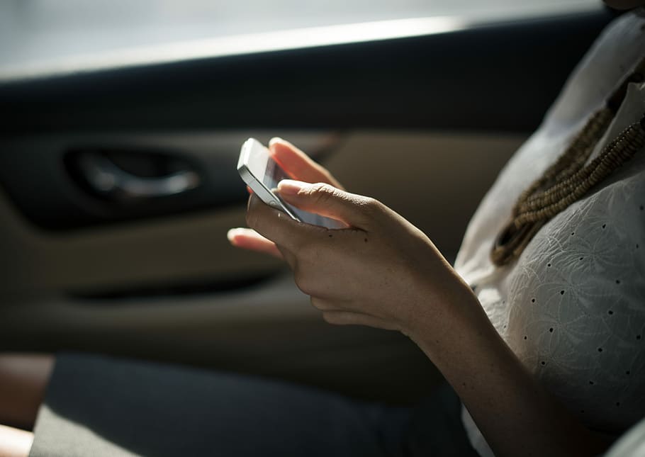 Woman using phone in car, closeup photo of person holding phone HD wallpaper